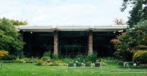 A modern house exterior with surrounding gardens and lawn chairs, ideal for outdoor relaxation.