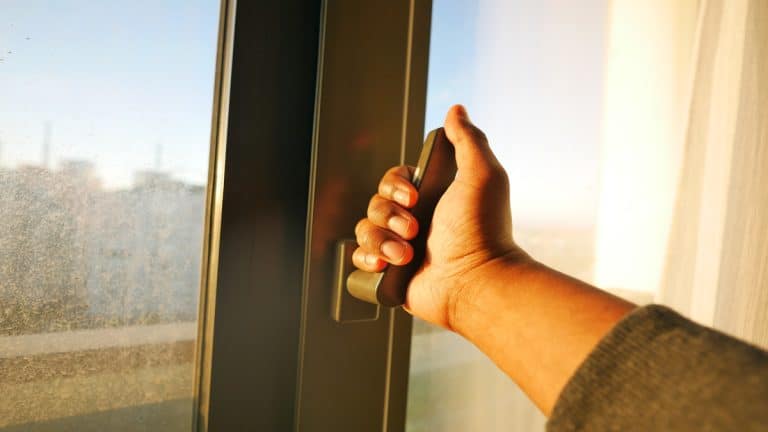 hand open gray plastic pvc window at home at early morning