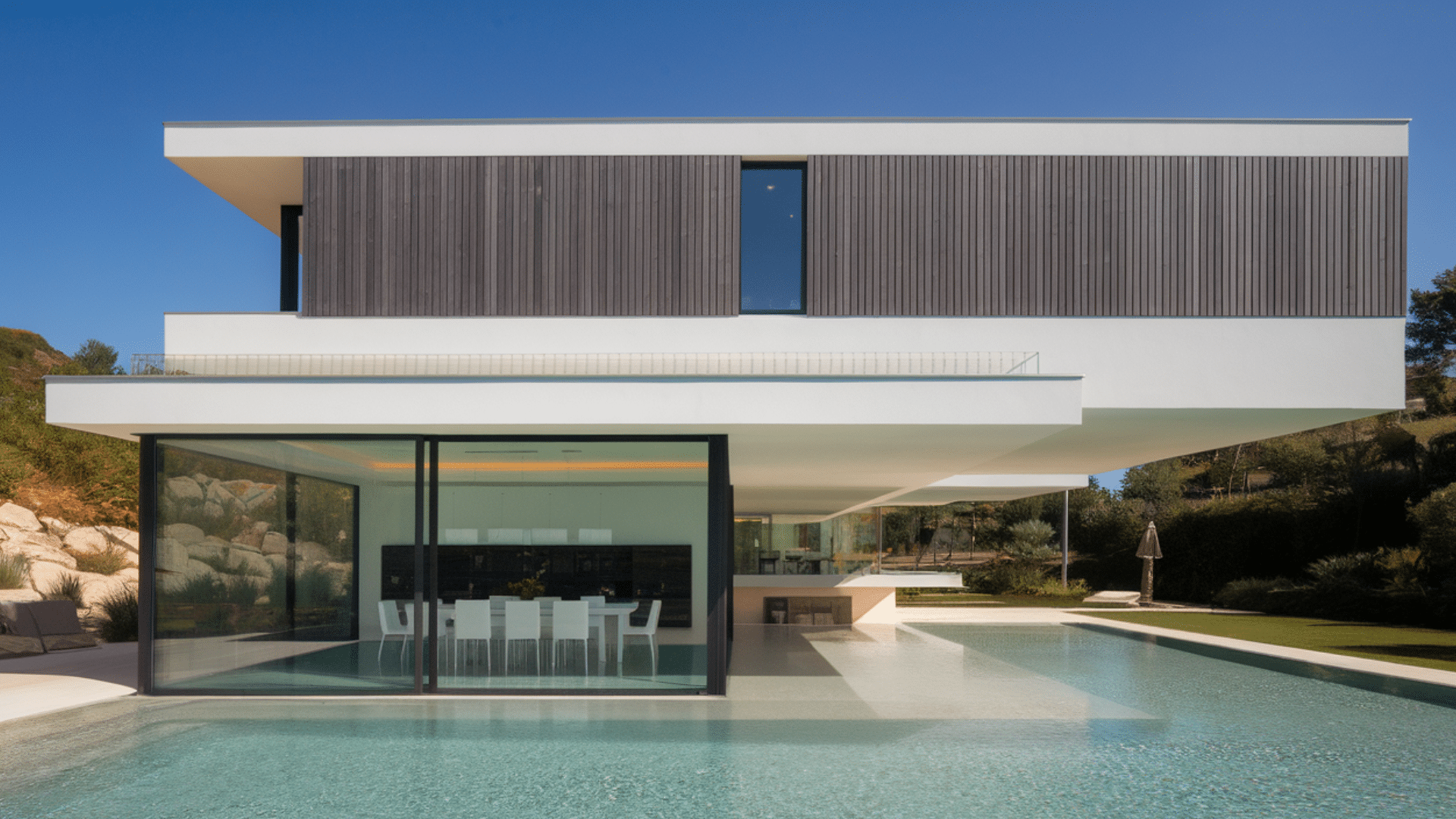 modern pool design that wraps around exterior layout