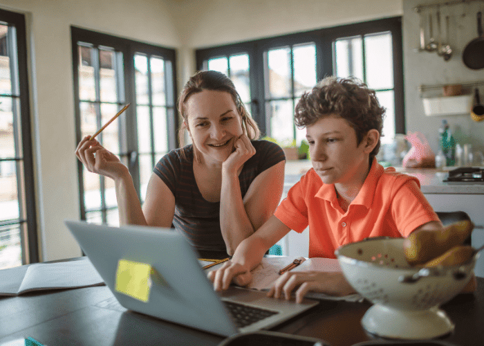 Mom and son completing homeschool lesson on laptop