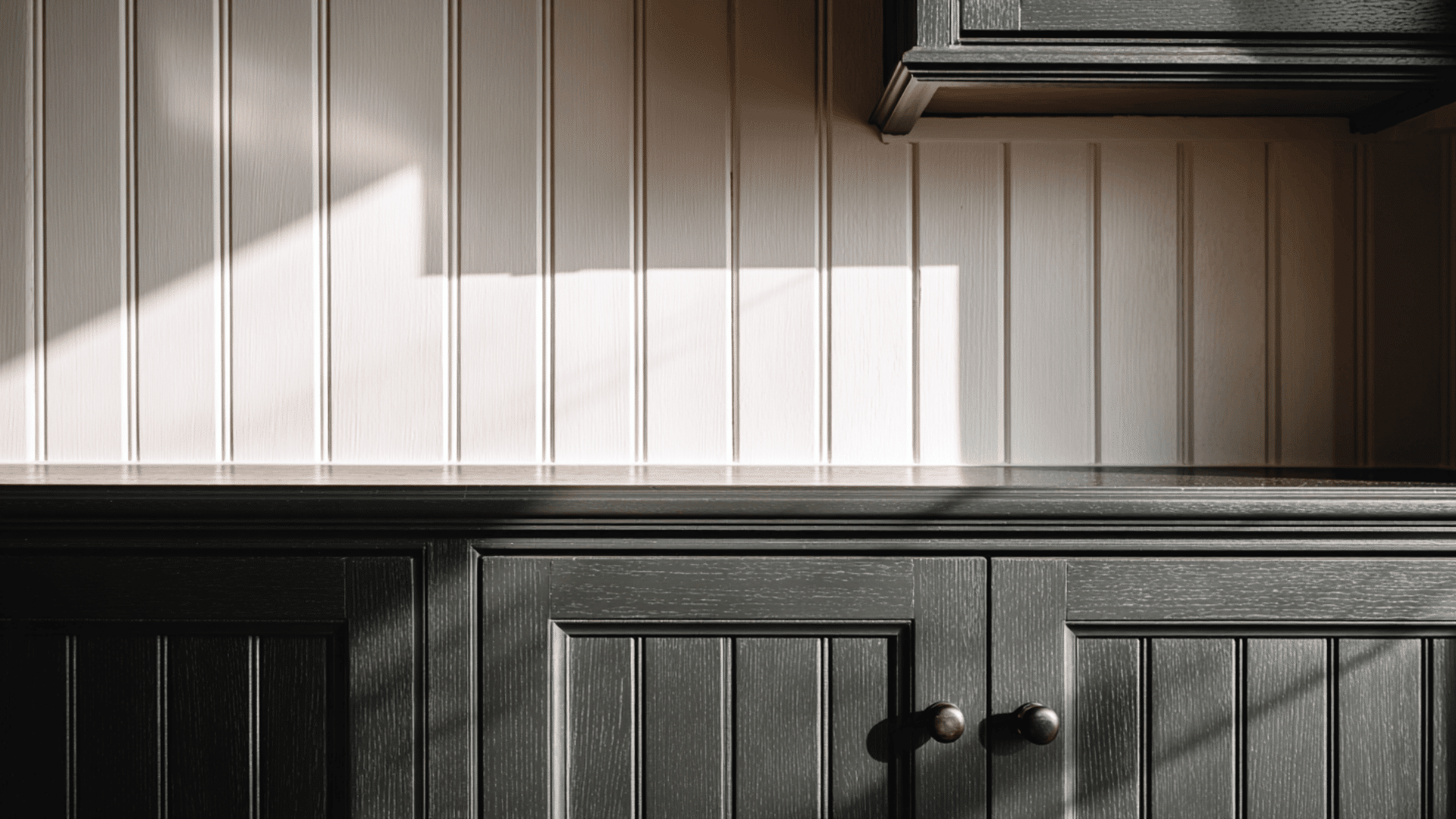 black cabinets with beadboard or shiplap walls