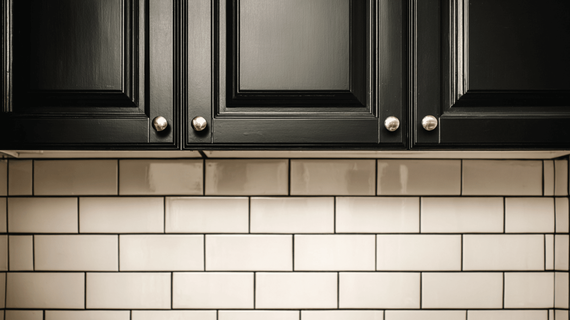 black cabinets with subway tile backsplash