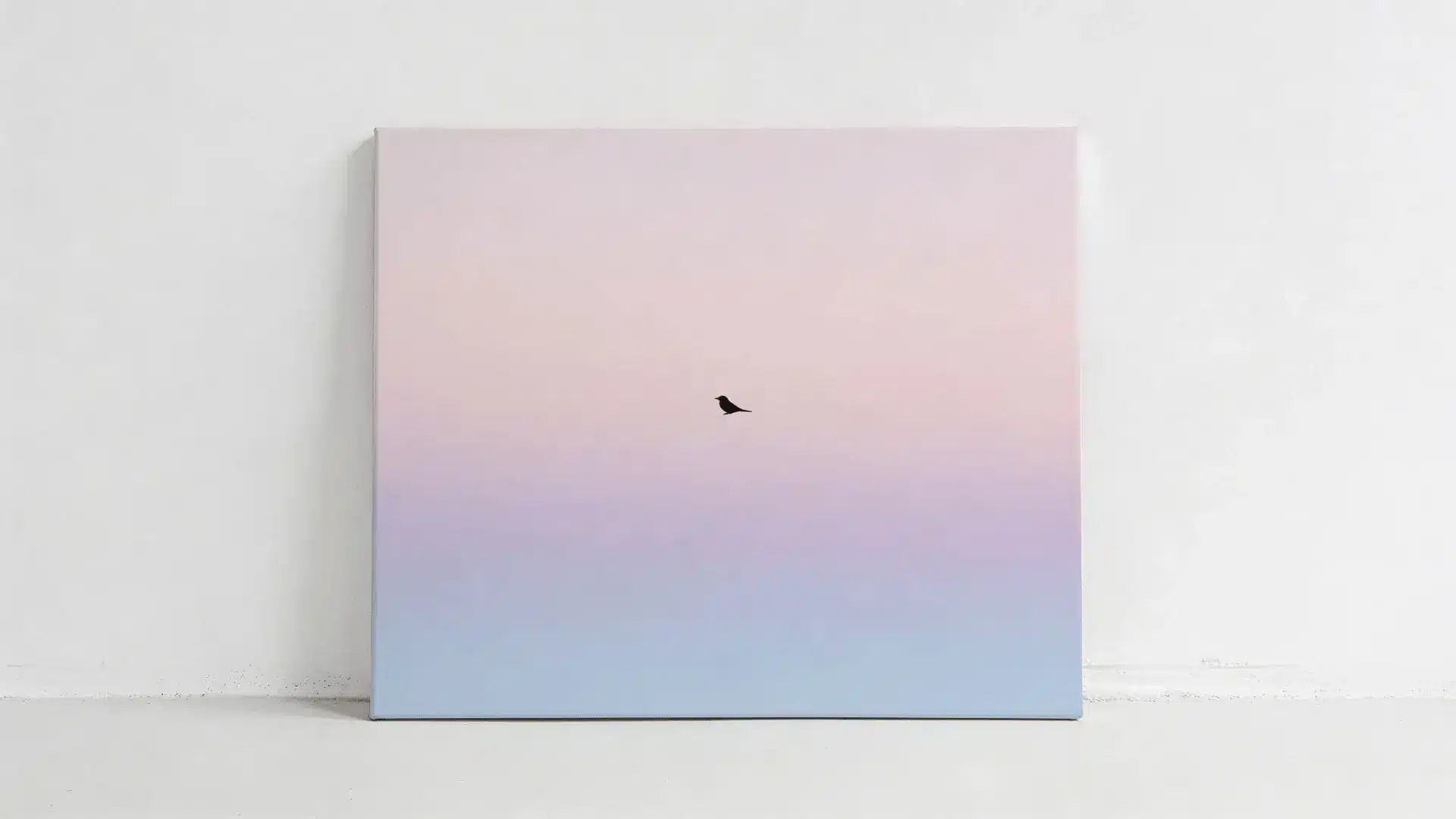 Canvas with pastel pink and blue sky and a single small black bird silhouette