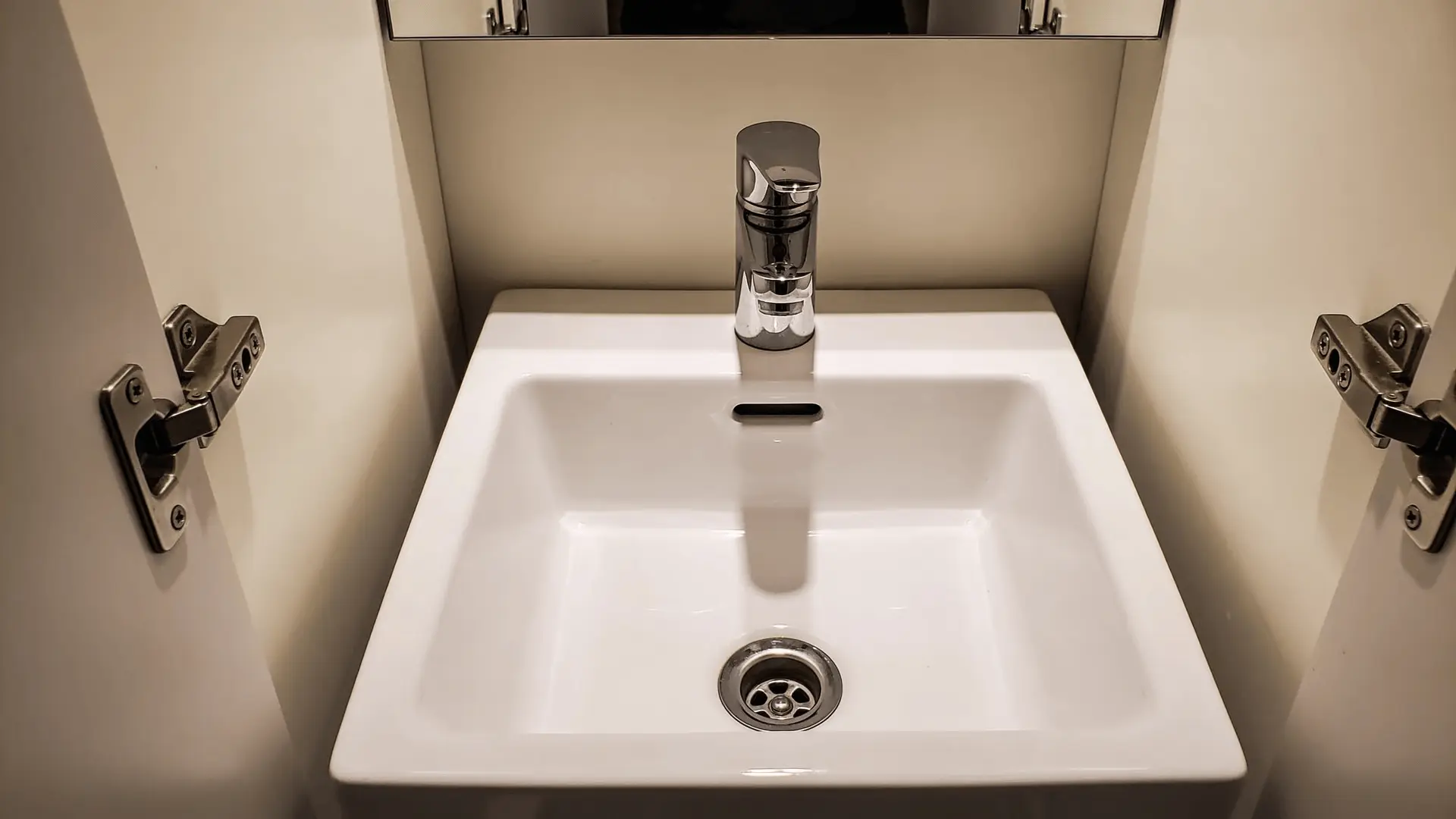 Compact bathroom sink in narrow powder room vanity