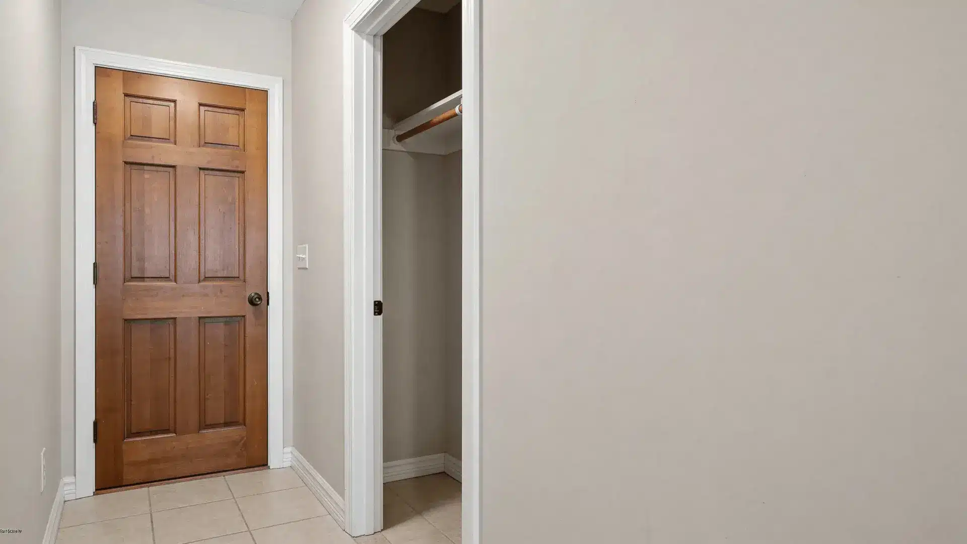 Open hallway coat closet with single rod inside