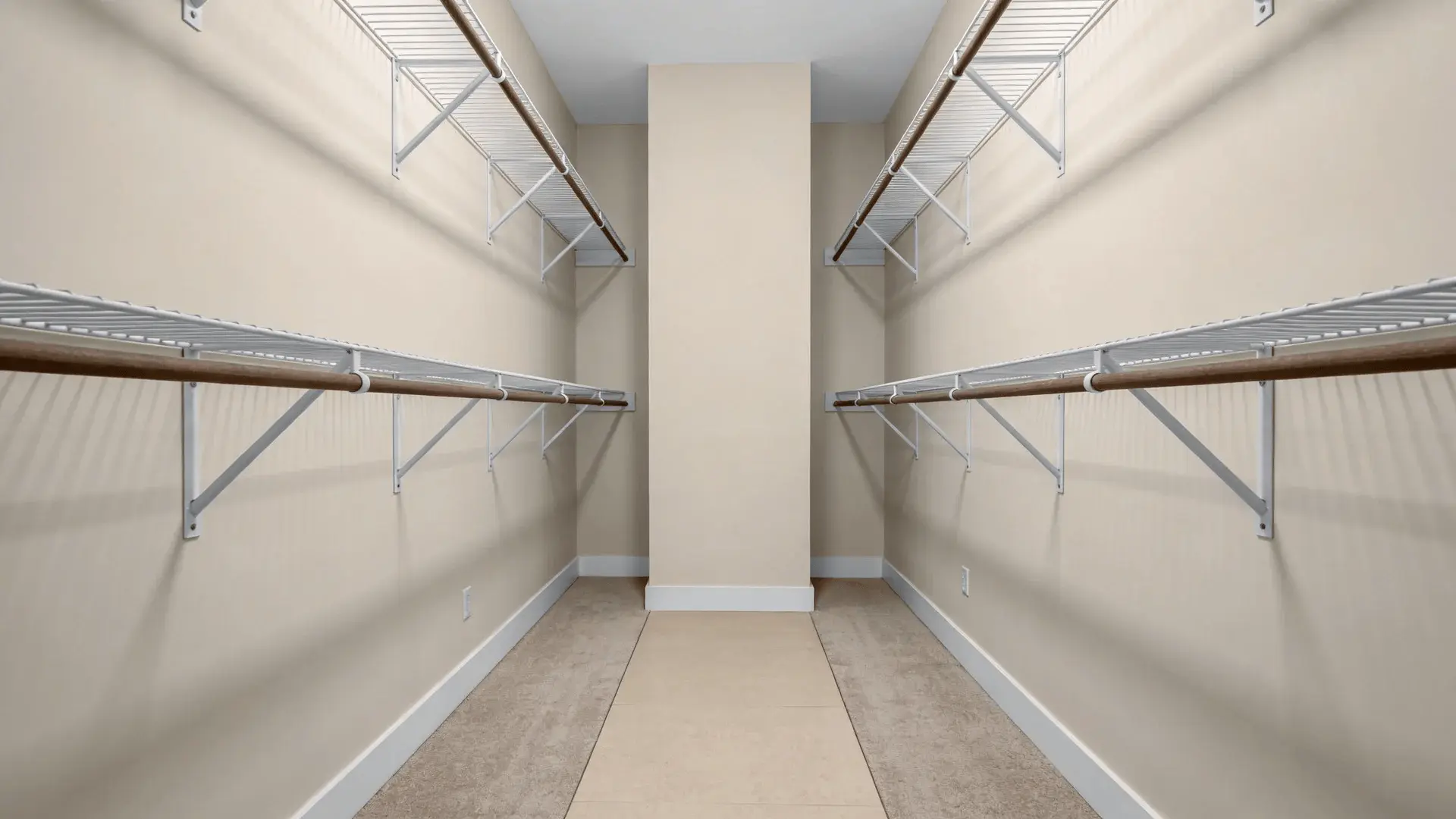Walk-in closet with hanging on both sides and wide central aisle
