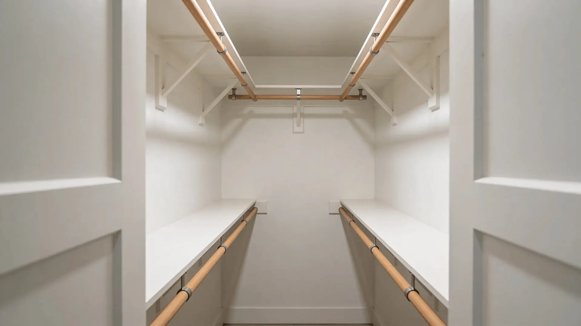 Walk-in closet with rods on both walls and open aisle space