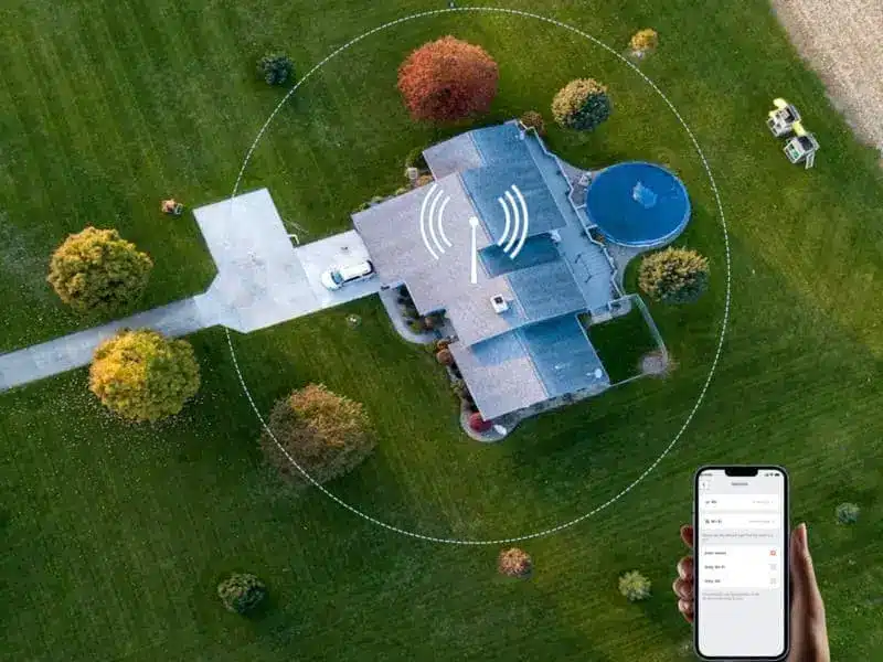 Overhead view of house with signal icon and phone app for smart home control