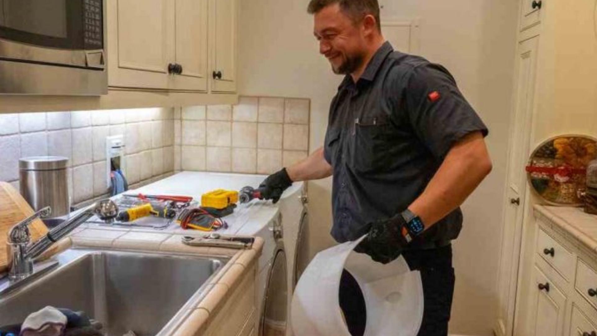 PrimeFix Technician repairing a washing machine with tools in a residential laundry area
