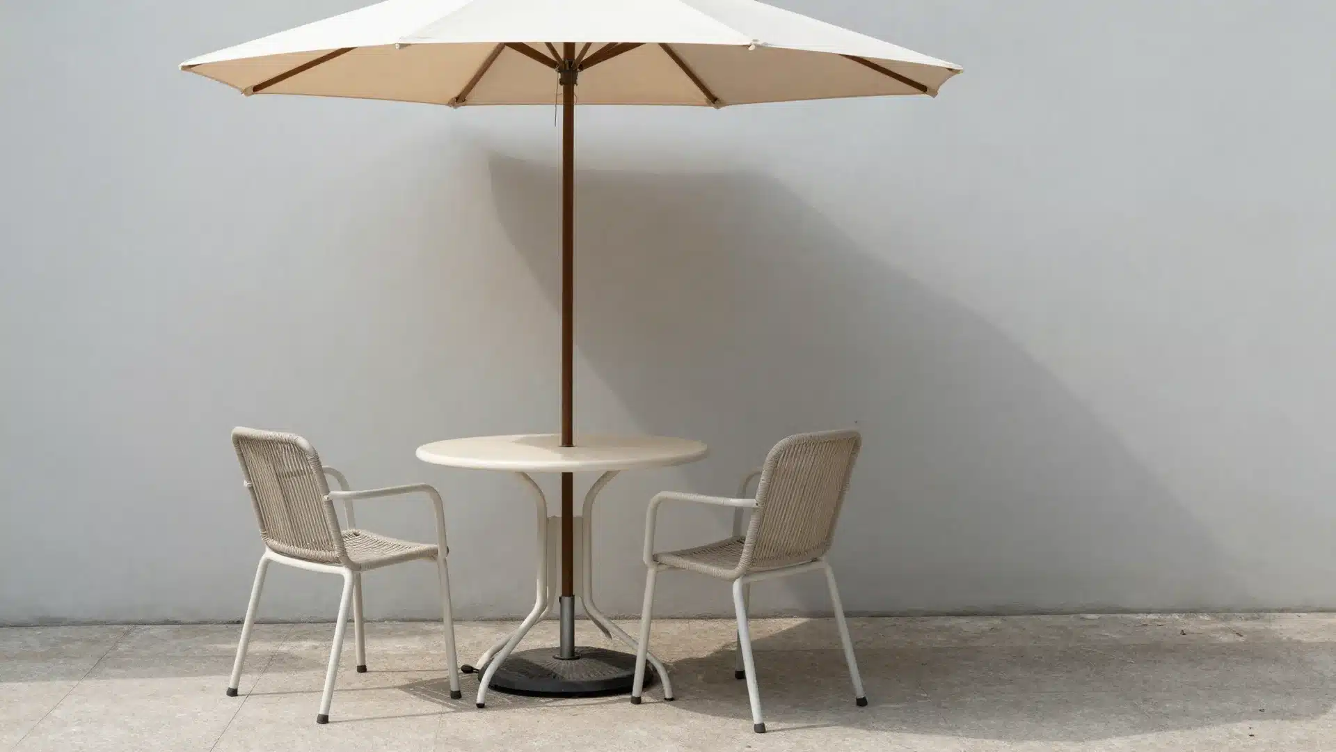 A compact outdoor dining area with a round table and chairs tucked into a sunny corner of a small backyard.