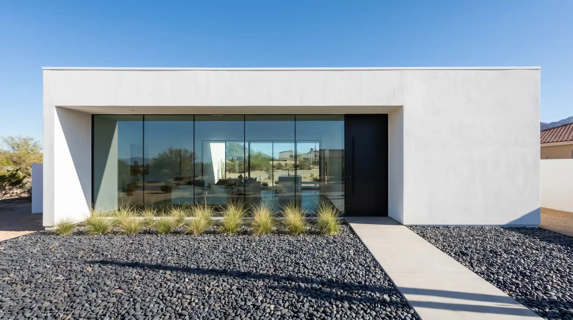A minimalist modern home with a boxy shape, flat roof, and a clean, two-tone color palette with smooth siding.