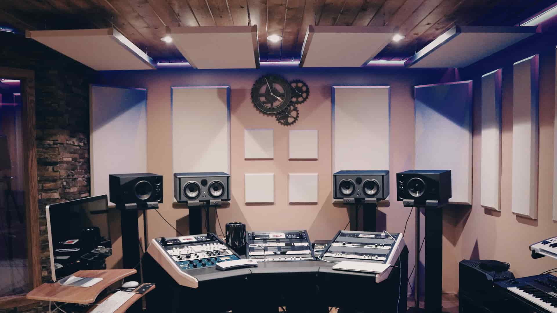 A sound-treated basement music studio with acoustic wall panels, instrument stands, and comfortable seating for practice