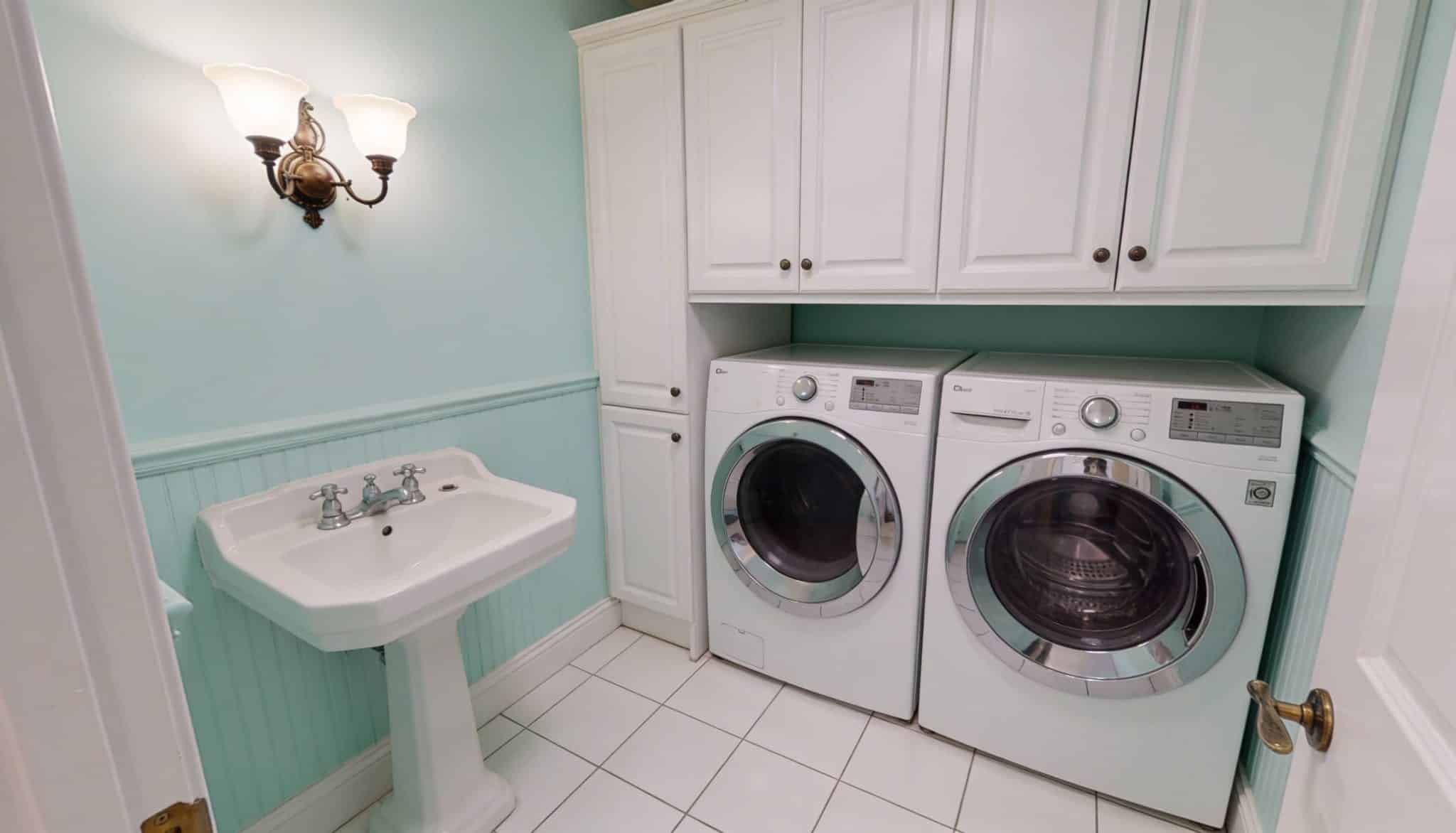 Vintage-inspired laundry room painted in a light, refreshing mint green with classic white accents.