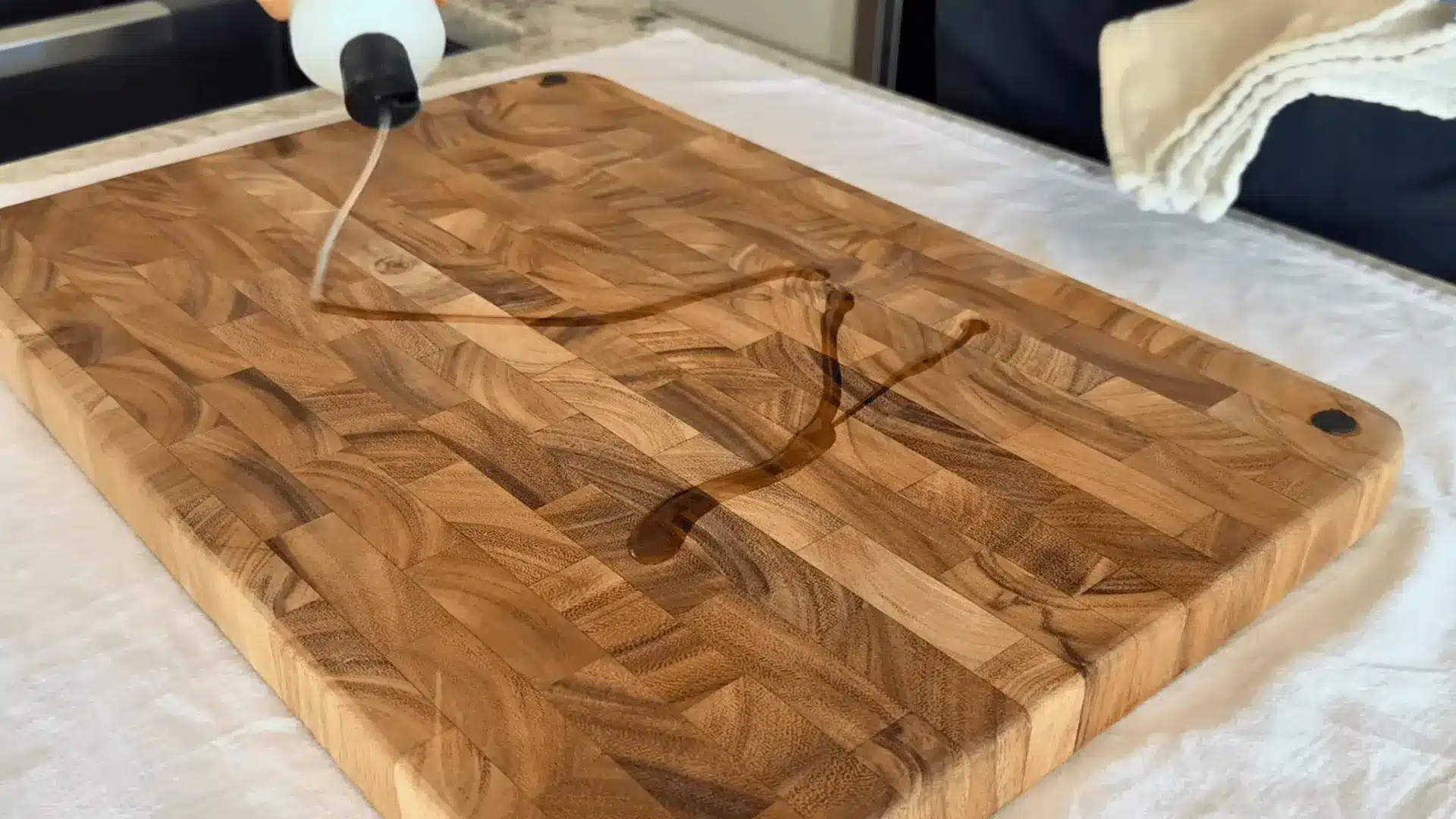 applying food grade mineral oil to a wooden cutting board to restore moisture and prevent cracking