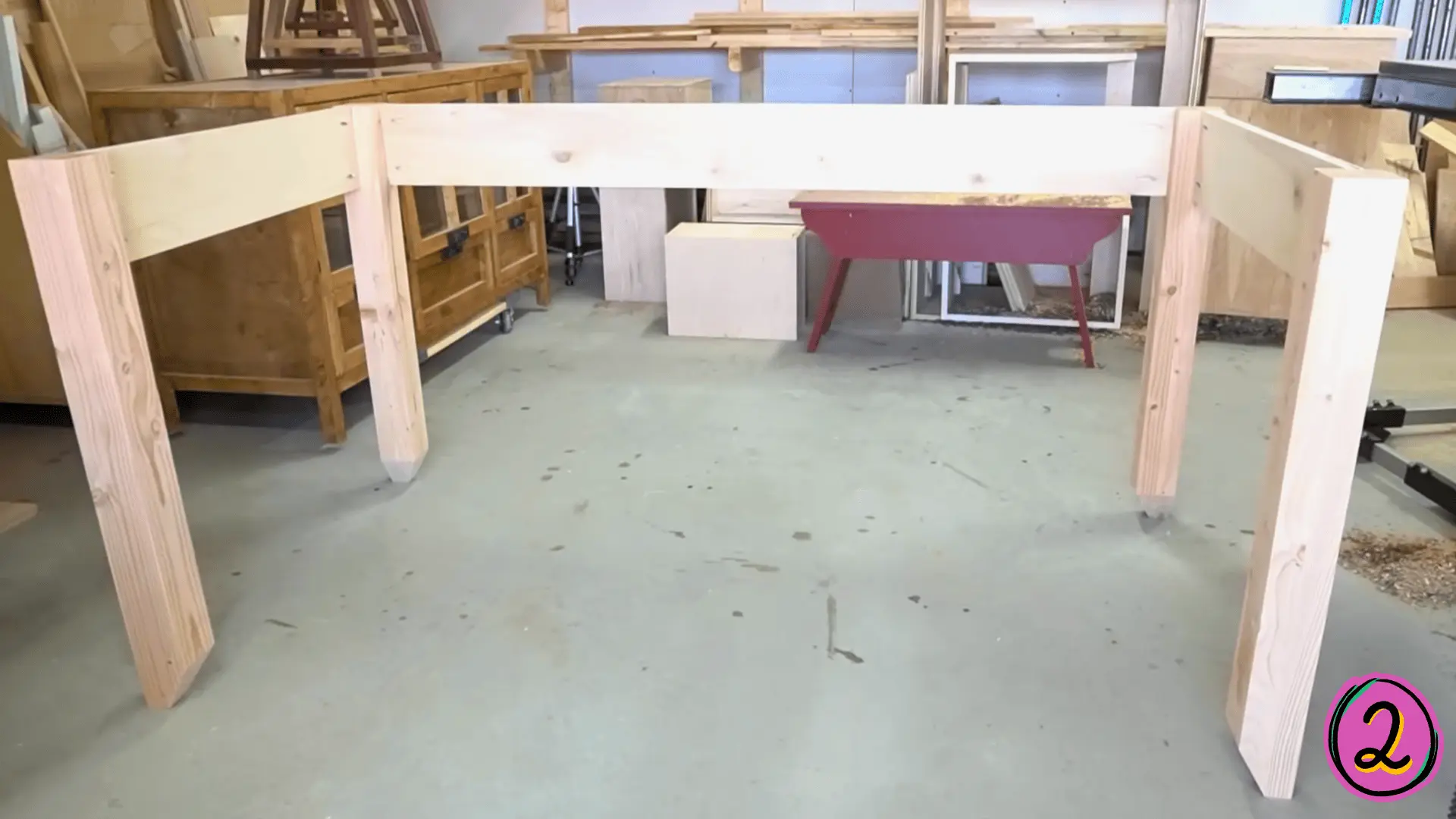 assembled pine wood desk frame with four legs and aprons in a woodworking workshop