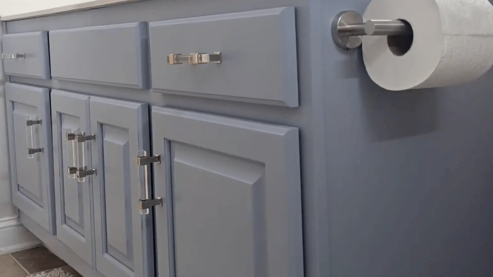 finished bathroom vanity painted in soft gray with new chrome hardware for a clean, modern look