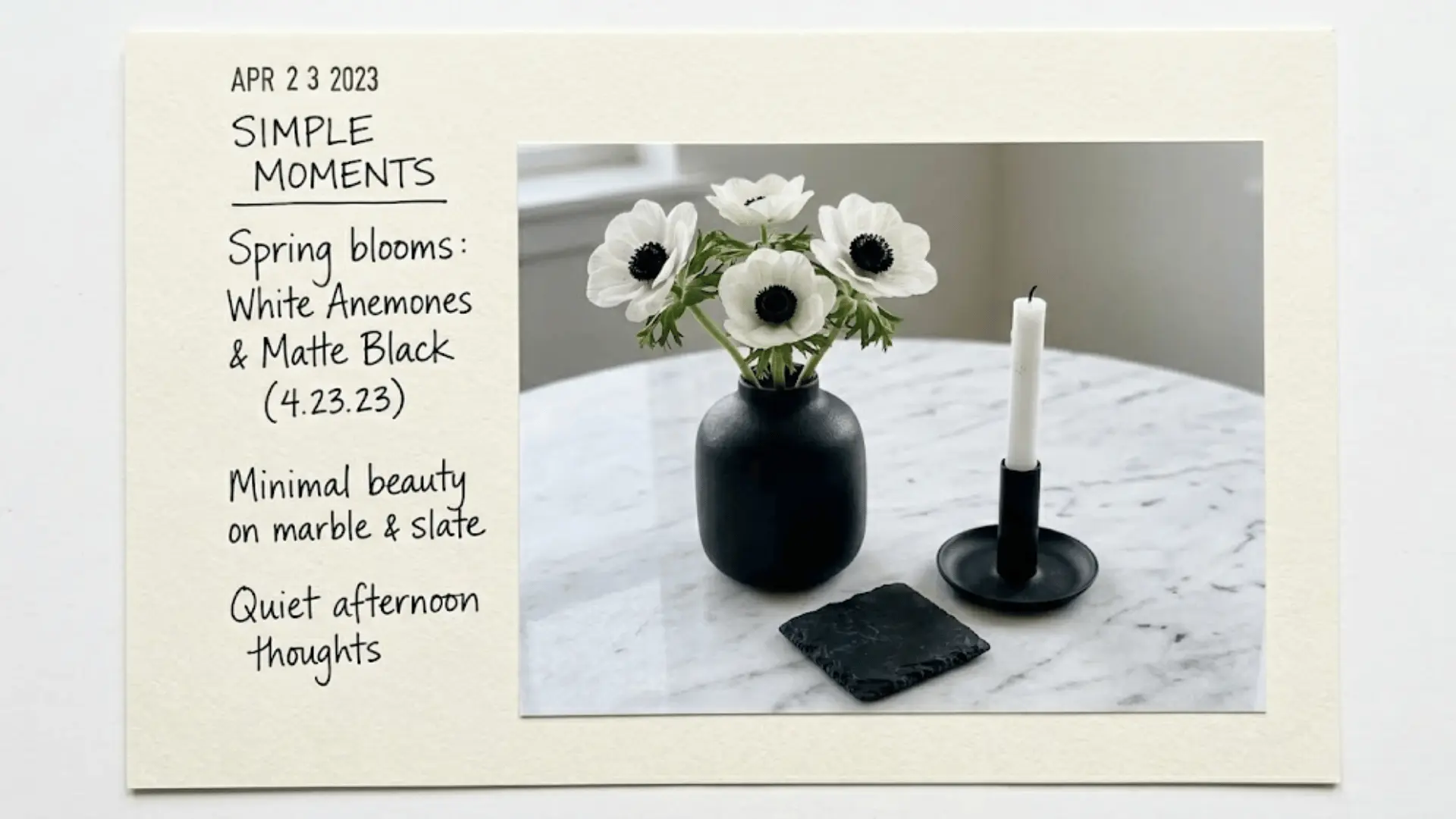 matte black vase with white anemones and black iron taper candle as monochrome dining table centerpiece