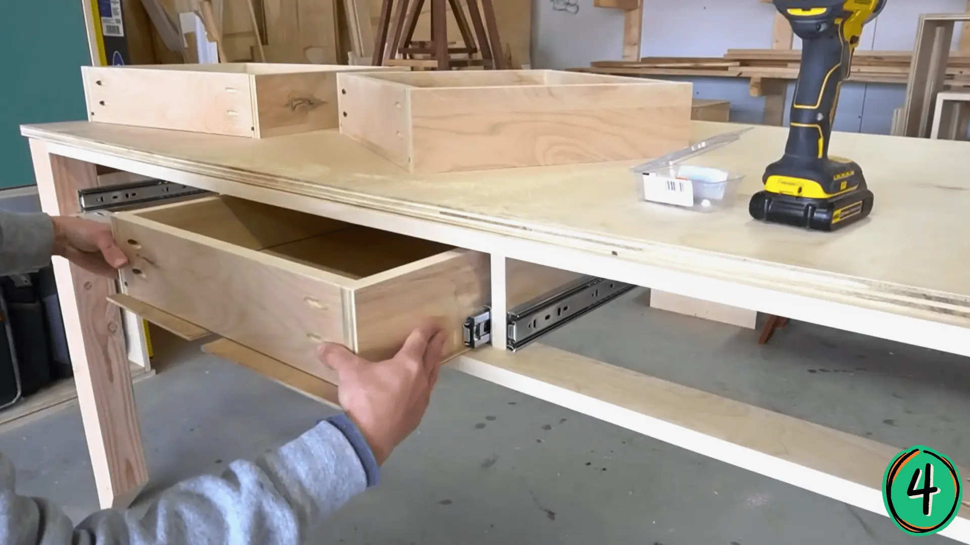 plywood drawer boxes being fitted into a diy desk frame with ball bearing slides
