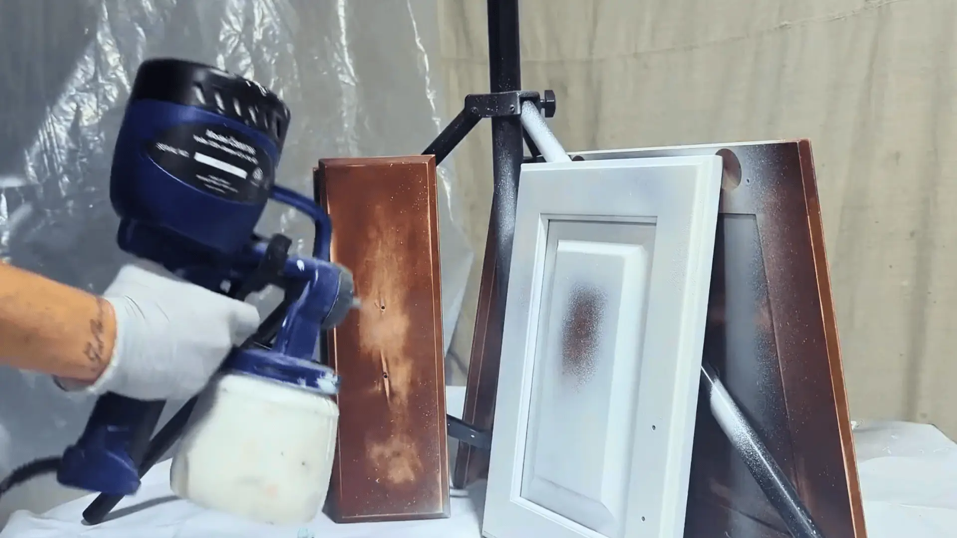 using a paint sprayer to apply paint on bathroom vanity cabinet doors for a smooth, even finish