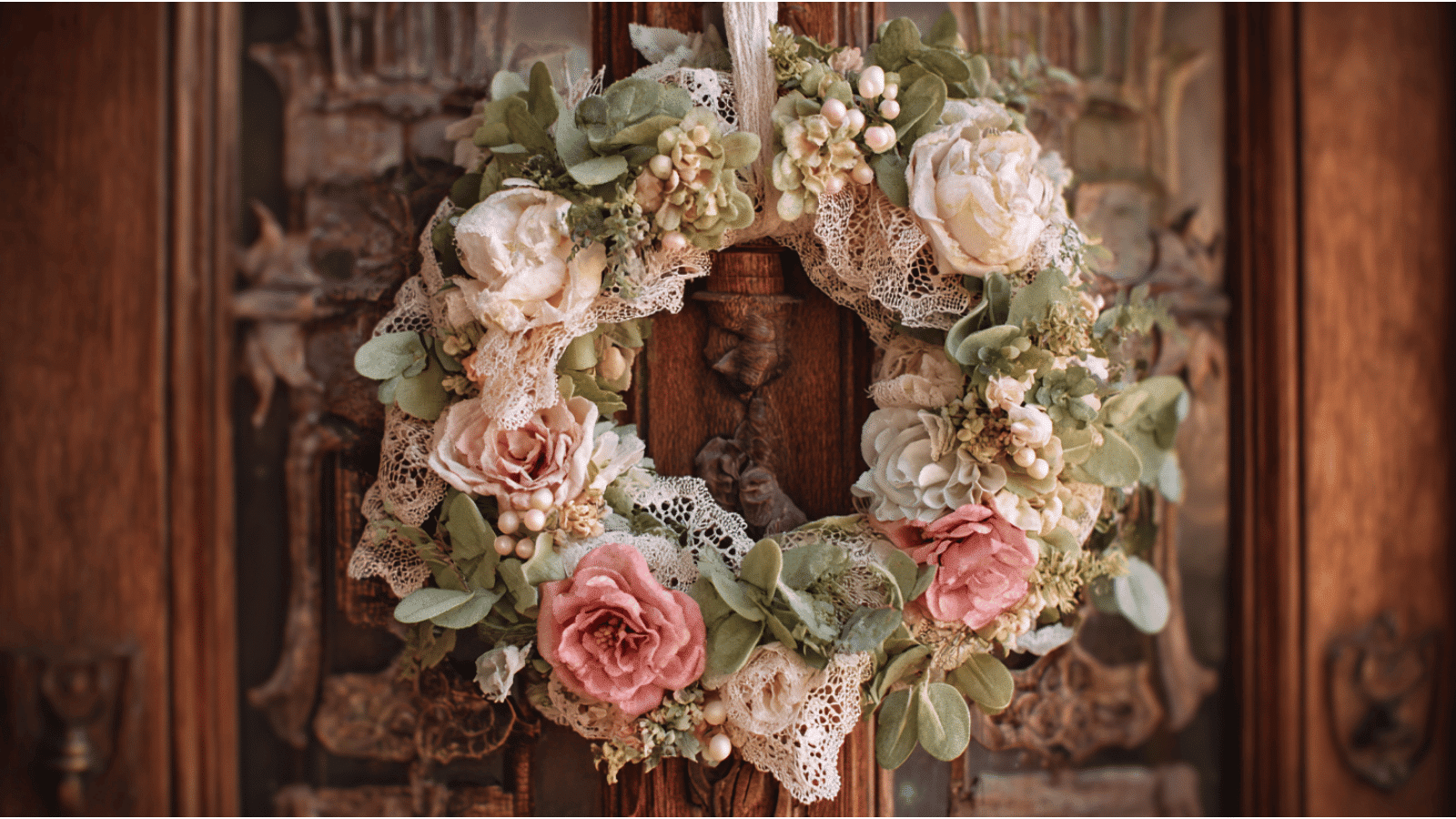 vintage lace wreath with pastel roses lace ribbons and soft greenery hanging on an antique wooden front door