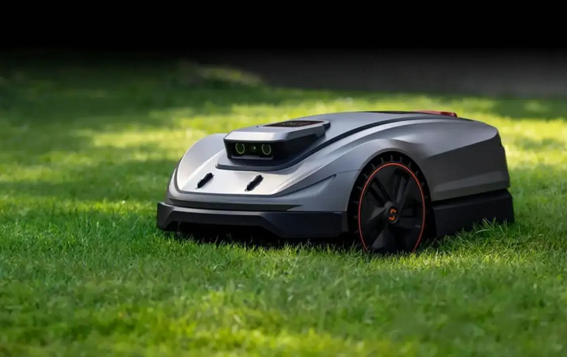 Robotic lawn mower on neatly cut grass in a sunny outdoor setting