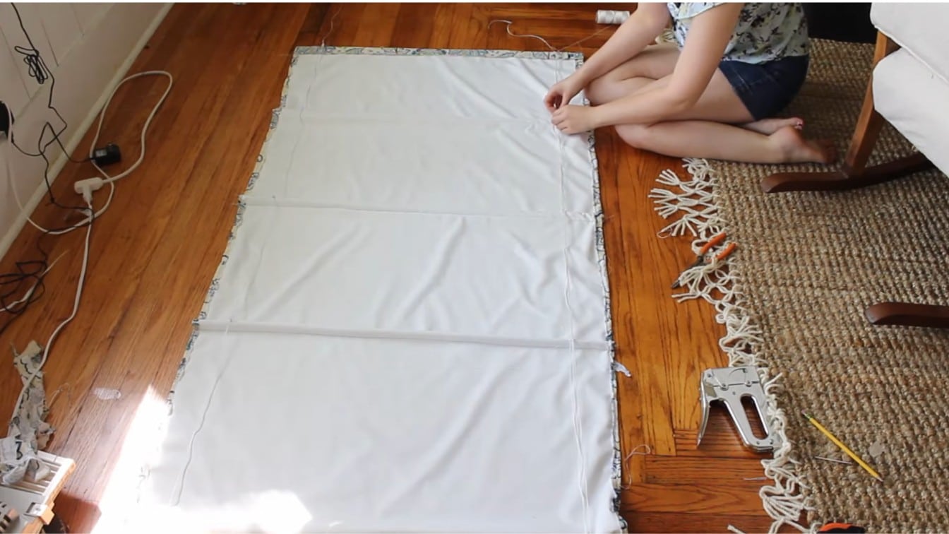 roman shade laid flat with white lining, dowel pockets, and ring placement marks visible on fabric