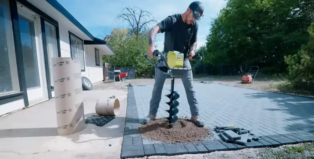 digging deep post holes in the marked area to prepare for setting the pergola support posts