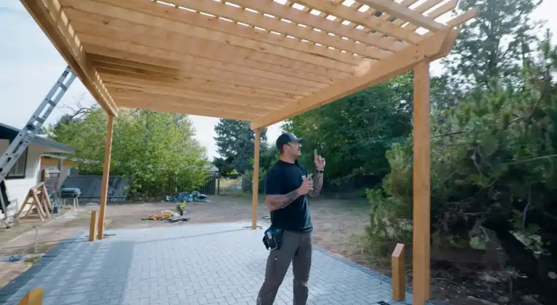 fitting evenly spaced rafters and top slats across the beams to create shade and structure